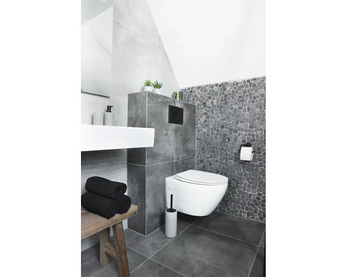 Badezimmer mit Wand-WC, Waschbecken, Bank und grauen Fliesen.