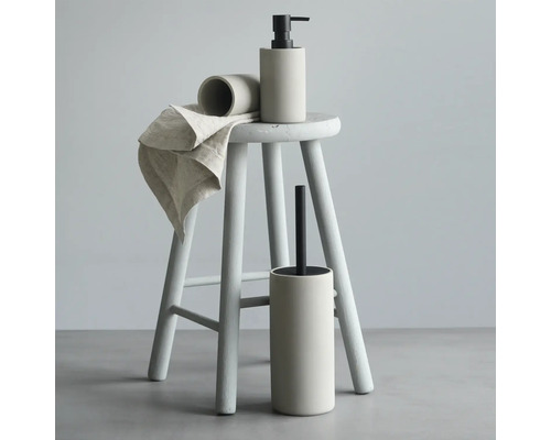 Badezimmerzubehör-Set mit Seifenspender, Becher, Toilettenbürste und Handtuch auf einem Hocker
