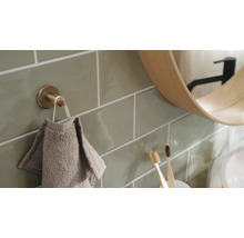Badezimmeransicht mit Handtuchhaken, Handtuch, Spiegel und Fliesen