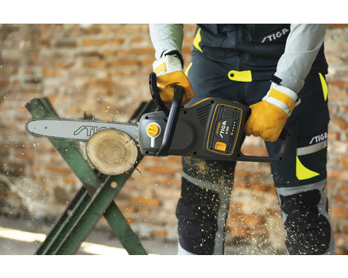 Person sägt Holzscheit mit einer Stiga Elektro-Kettensäge auf einem Sägebock