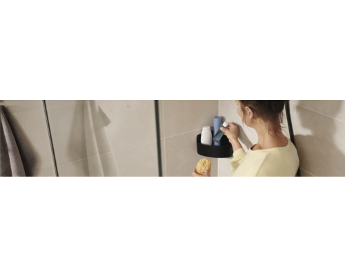 Frau mit Badeschwamm und Duschgel im Badezimmerregal