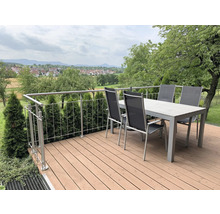 Terrasse mit Esstisch, Stühlen und Geländer im Garten