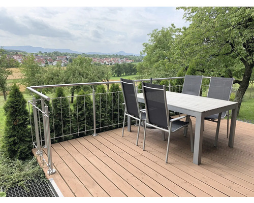 Terrasse mit Esstisch, Stühlen und Geländer im Garten