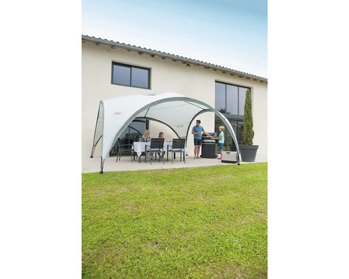 Familie beim Grillen unter einem Partyzelt im Garten