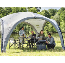 Szene mit Pavillon, Tisch, Stühlen und Kühlbox im Freien, umgeben von Menschen