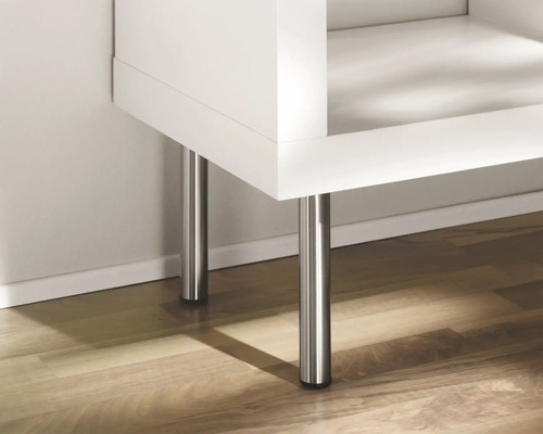 Detailansicht eines weißen Möbelstücks mit silberfarbenen Metallfüßen auf einem Holzboden.