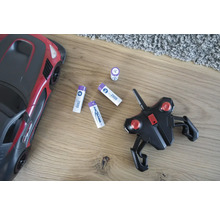 Spielzeugauto mit Fernbedienung und Batterien auf einem Holzboden