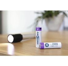 Zwei Ansmann AA Batterien und eine Taschenlampe auf einem Tisch