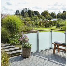Garten Szene mit Sichtschutzzaun, Pflanzkübel und Sitzbank auf einer Terrasse.
