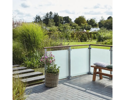 Garten Szene mit Sichtschutzzaun, Pflanzkübel und Sitzbank auf einer Terrasse.