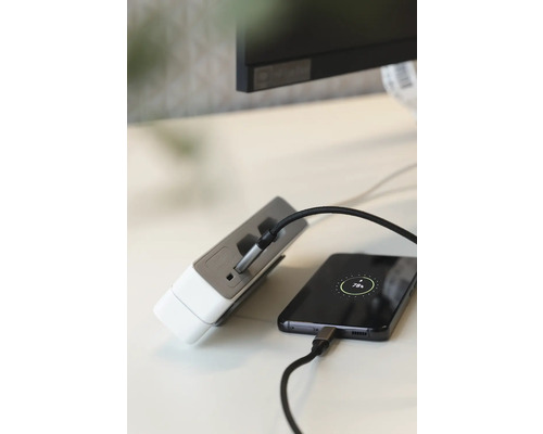 Mehrfachsteckdose mit USB Anschlüssen lädt ein Mobiltelefon auf