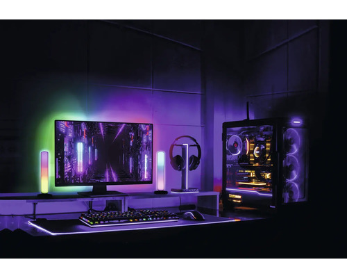 Gaming-Setup mit Computer, Bildschirm, Tastatur, Maus, Kopfhörer und LED-Beleuchtung für ein immersives Spielerlebnis