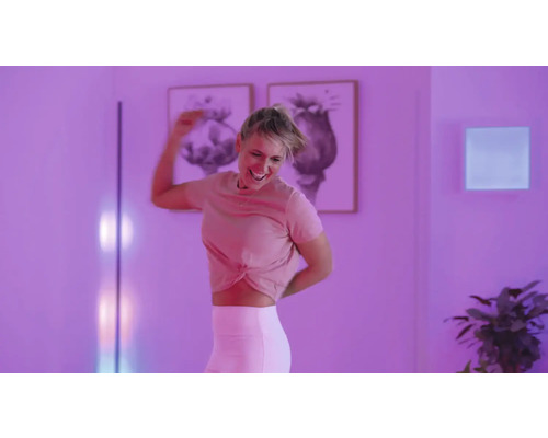 Frau tanzt in einem Zimmer mit Stehlampe und Wandleuchte