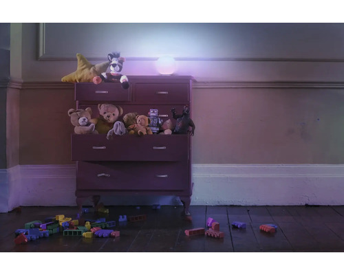 Kommode mit Spielzeug und einer runden Lampe im Kinderzimmer