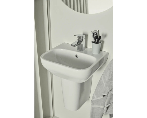 Waschtisch mit Armatur und Handtuch in einem Badezimmer