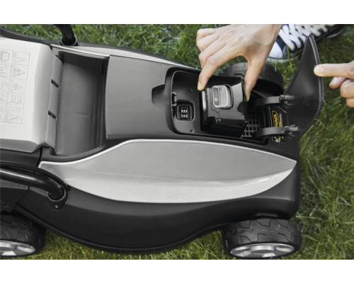 Aufsicht auf einen Rasenmäher, wobei eine Person den Akku wechselt.