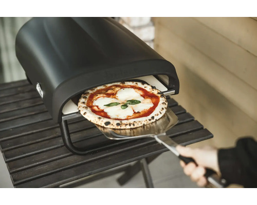 Pizzaofen mit Pizza auf Pizzaschieber