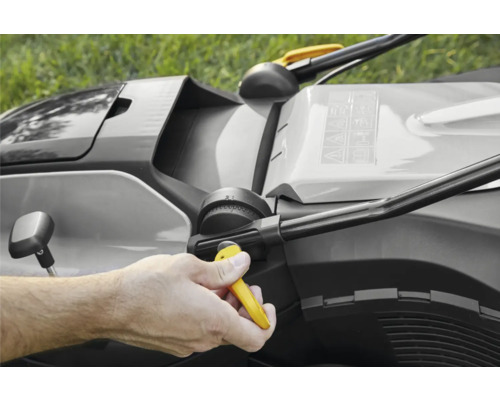 Hand, die die Schnitthöhe eines Rasenmähers einstellt