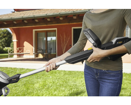 Frau hält einen Akku-Rasentrimmer von Alpina im Garten