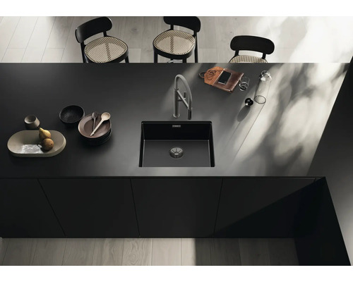 Küchenspüle aus Verbundwerkstoff mit Armatur auf einer dunklen Arbeitsplatte