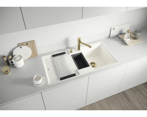 Küchenspüle mit Abtropfgestell, Spülmittelspender und Armatur in einer hellen Küche.