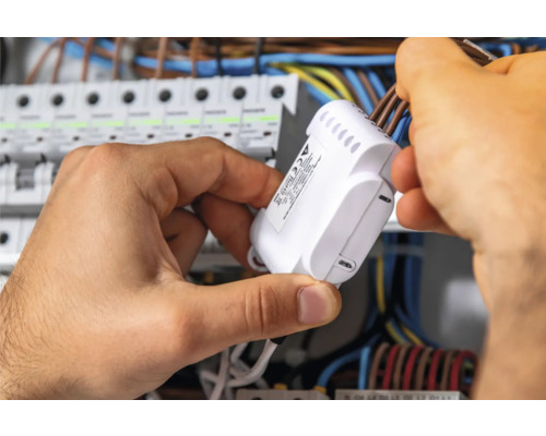 Elektriker montiert Verteiler in einem Schaltschrank