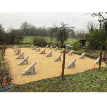 Bauplatzvorbereitung mit Betonfundamenten für ein Gartenprojekt im Außenbereich.