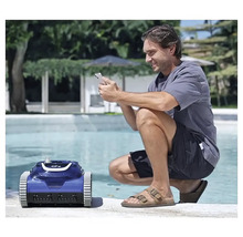 Mann bedient Poolreinigungsroboter mit einem Smartphone an einem Pool