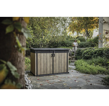 Gartengeräteschrank mit Holzeffekt und Frau im Hintergrund in Gartenlandschaft