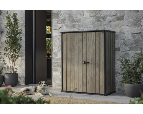 Geräteschrank mit Holzoptik und Hund im Außenbereich