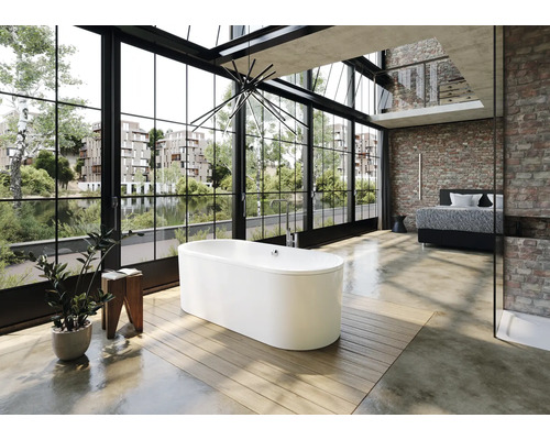 Freistehende Badewanne in einem hellen Badezimmer mit großem Fenster und Ziegelwand.