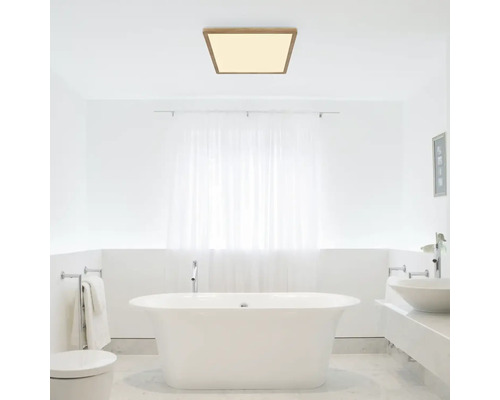 Modernes Badezimmer mit freistehender Badewanne und quadratischer Deckenleuchte mit Holzrahmen