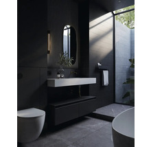 Modernes Badezimmer mit Toilette, Waschtisch, Spiegel und Badewanne