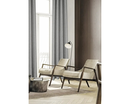 Wohnzimmer mit Sesseln, Stehlampe und Vorhängen