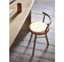Holzstuhl mit Schaffellauflage an einem Holztisch