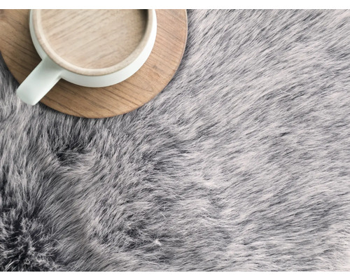 Dekoratives Fell mit Tasse auf Holzuntersetzer