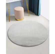 Runder, flauschiger Teppich im Interieur mit Hocker und Tisch