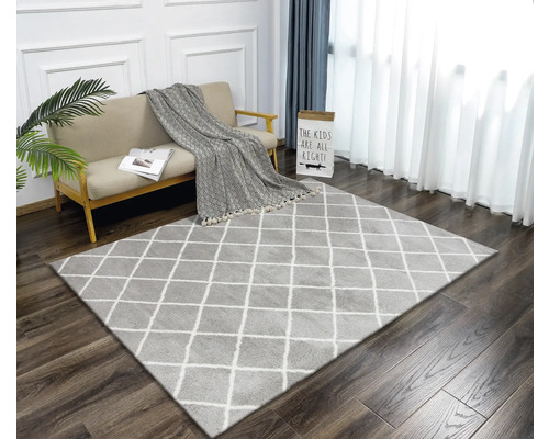 Wohnzimmer mit Teppich im Rautenmuster, Sofa und Vorhängen