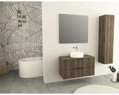 Badezimmer mit Waschtisch, Spiegel, Hochschrank, Badewanne und Blattmuster-Tapete