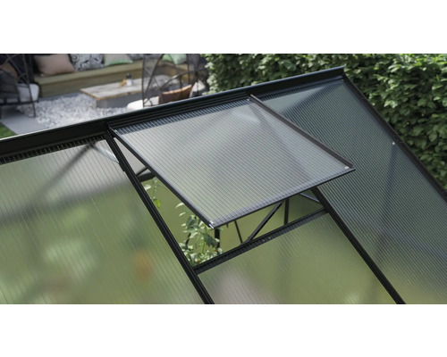 Detailansicht eines Gewächshauses mit geöffnetem Fenster zur Belüftung.