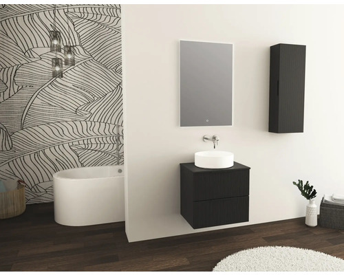 Badezimmer mit Waschtisch, Spiegel, Hängeschrank und freistehender Badewanne vor einer Wand mit Blattmuster