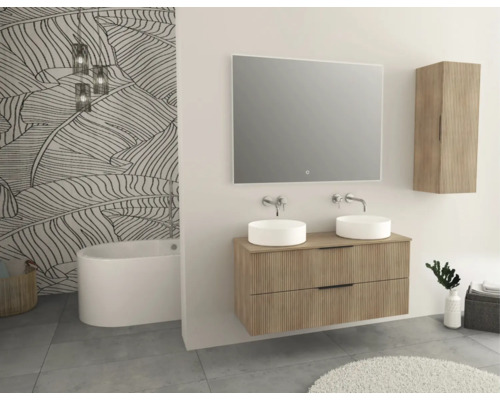 Badezimmer mit Doppelwaschtisch, Spiegel, Hängeschrank und Badewanne vor Blattmustertapete