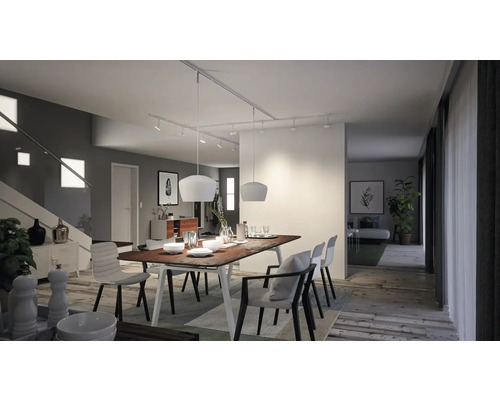 Heller Essbereich mit Holztisch, Stühlen und moderner Beleuchtung.