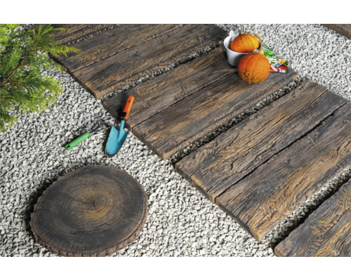Gartenszene mit Trittplatten in Holzoptik, Dekoration und Gartengeräten auf Kies