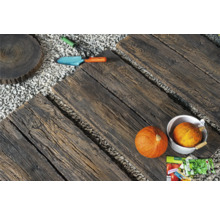 Gartenweg mit Trittplatten in Holzoptik, Kies, Kürbissen und Gartengeräten.