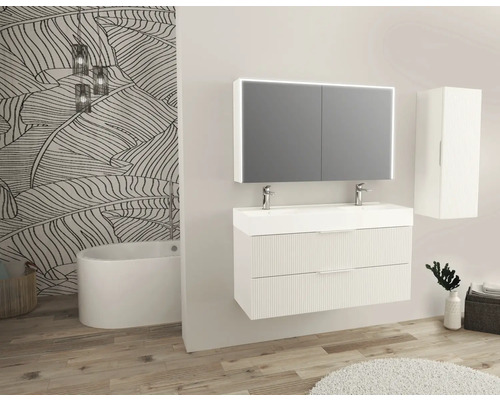 Modernes Badezimmer mit Waschtisch, Spiegelschrank, Hochschrank und Badewanne vor einer gemusterten Tapete