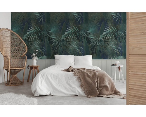 Schlafzimmer mit botanischer Tapete, Bett und Rattansessel