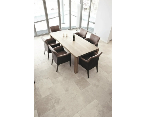 Heller Raum mit Esstisch und Stühlen auf Fliesenboden