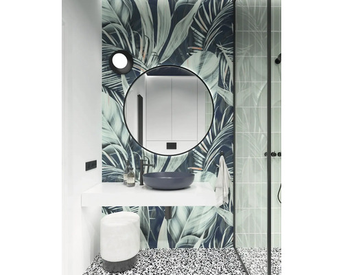 Badezimmer mit Waschtisch, Spiegel, Hocker und Pflanzenmuster-Tapete.