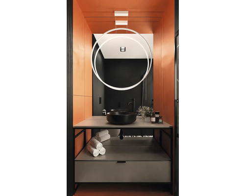 Modernes Badezimmer mit schwarzem Waschbecken, Handtüchern und kreisförmiger Lampe